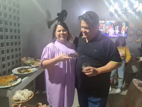 A aniversariante serve o primeiro pedaço do bolo.